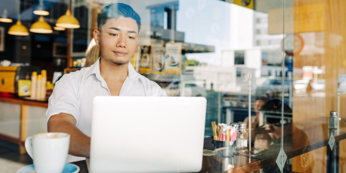 Learner with laptop in cafe