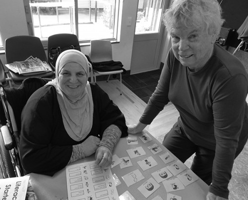 Syrian refugee and her English teacher at a table