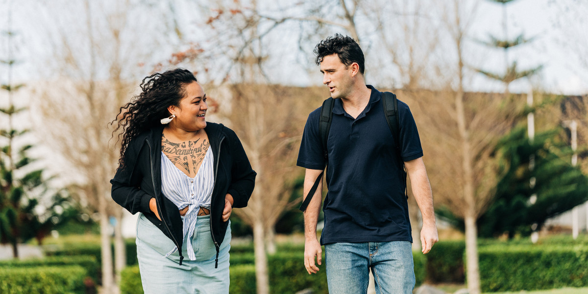 Two learners walking outide with trees in the background