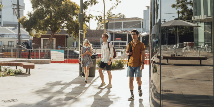Three students walking on campus