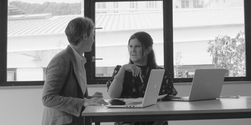 Two people talking in front of bright window